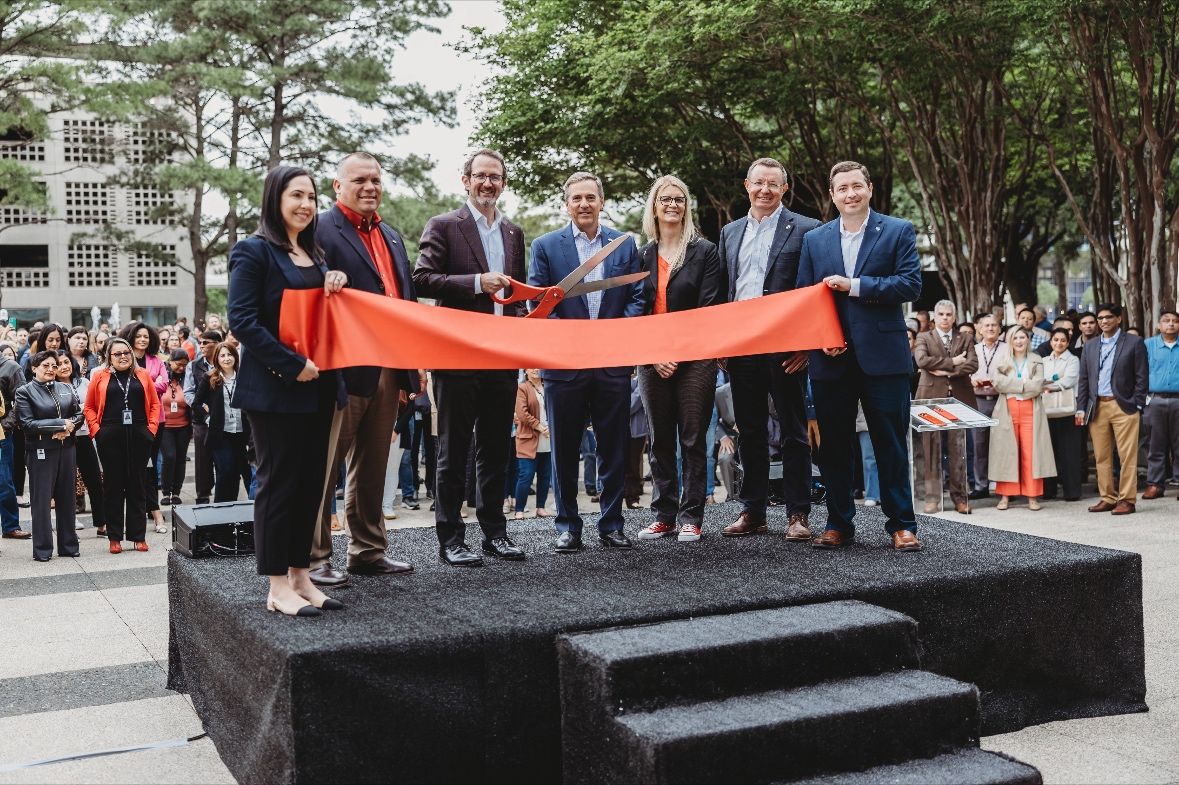 Paul Marsden, president of Bechtel Energy (pictured holding scissors) and other representatives from Bechtel participate in the ribbon cutting of their new headquarters in Westchase District.